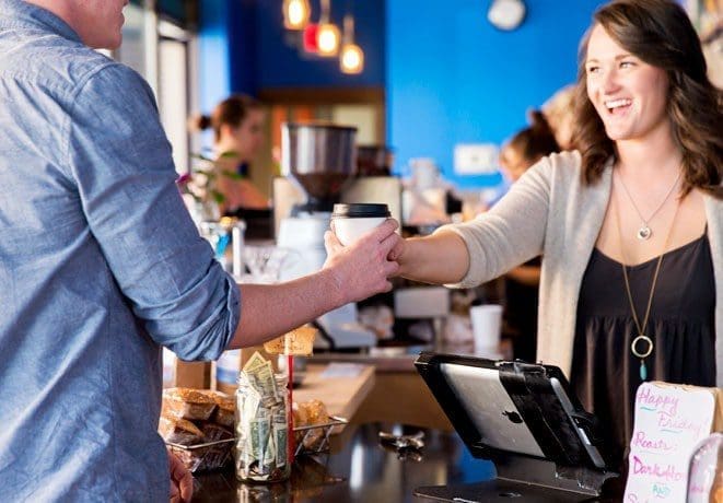 Matt Konen taking a cup of coffee from a barista in Bozeman, MT